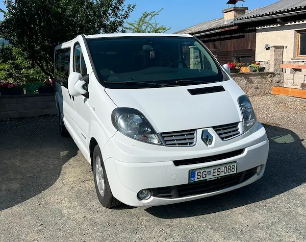 Bel kombi Renault, parkiran na dvorišču pred hišo.